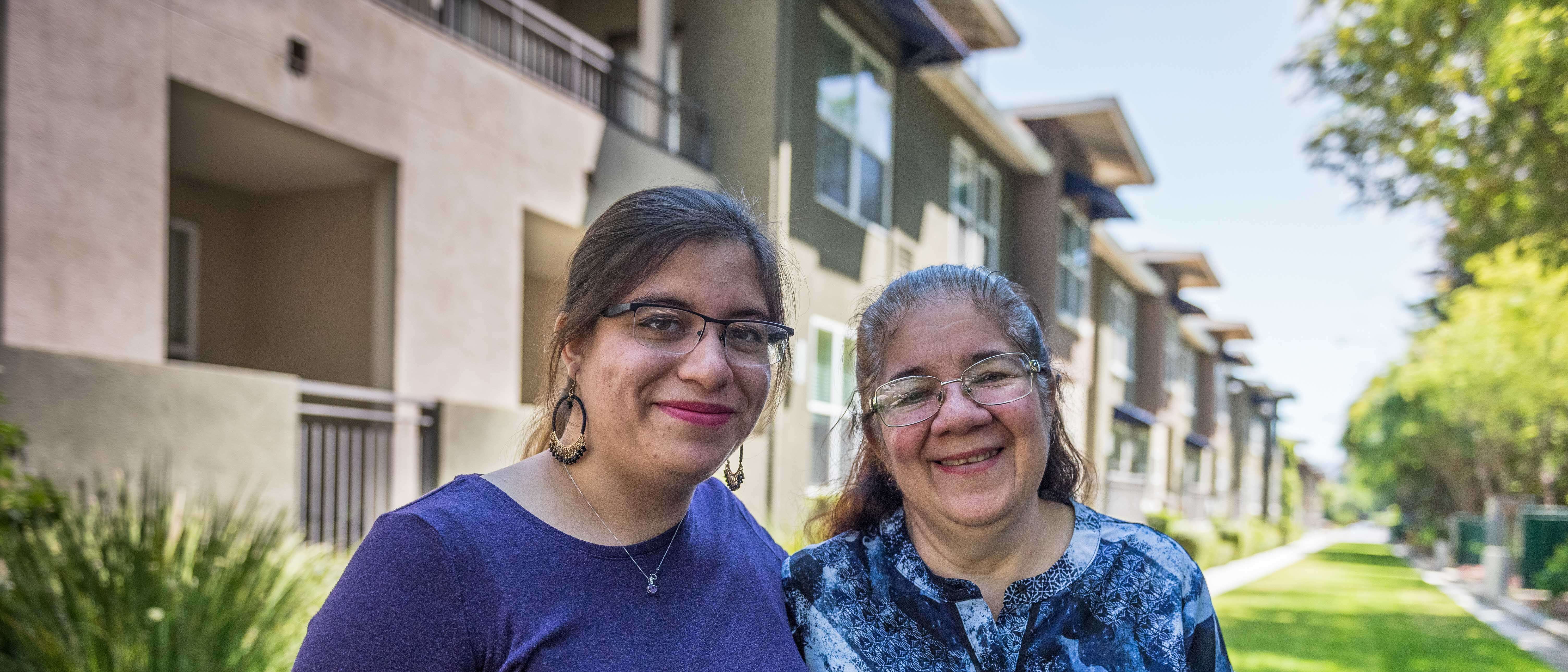 Two women stand next to each and pose for a picture.