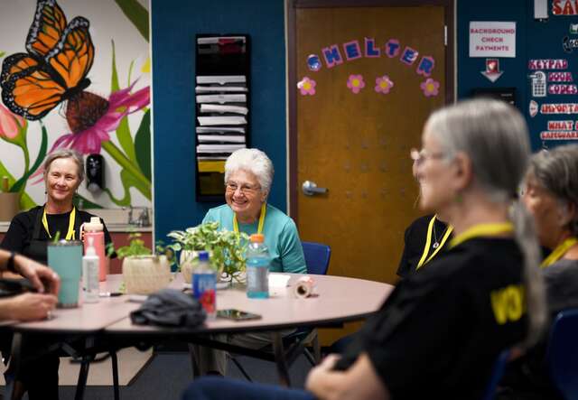A group of IRC volunteers sit together at a table during a meeting.